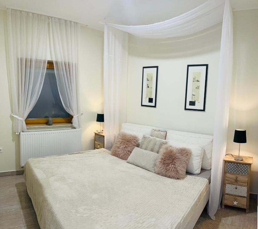 ガールドニにあるVilla Relax Apartmanのベッドルーム(白いカーテン付きの大型白いベッド1台付)