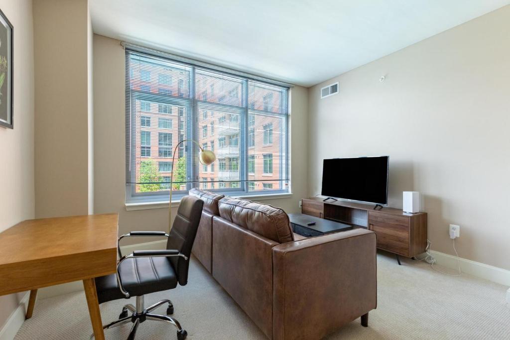 a living room with a couch and a table and a television at Reston 1br w biz center 5 mi from hospital WDC-834 in Reston