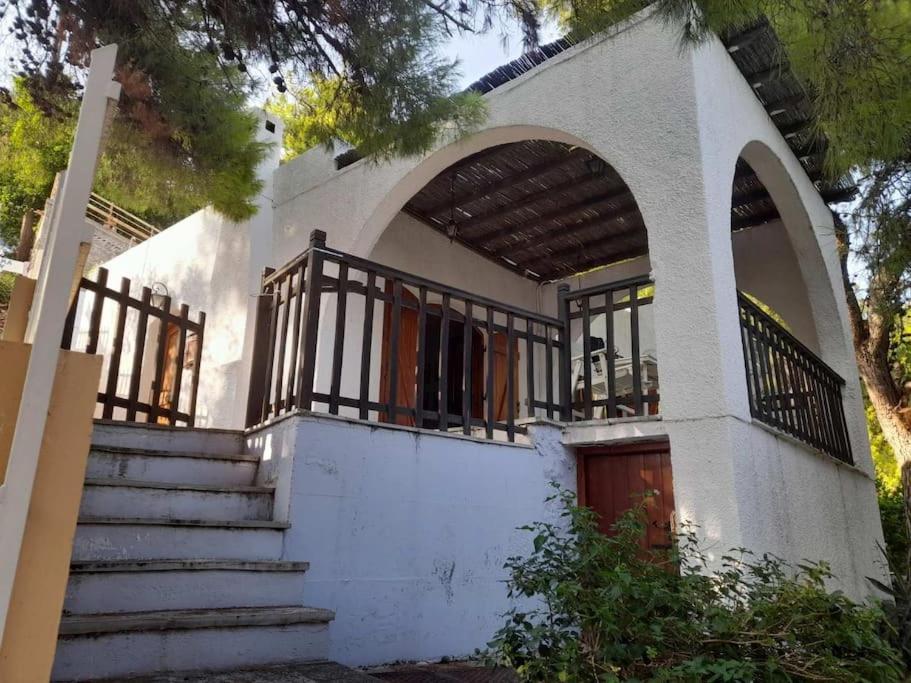 a white house with stairs and a balcony at Mike's Cycladic Villa in Poros