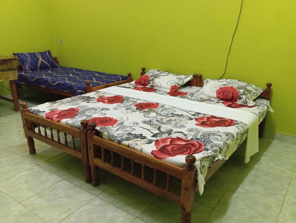 1 dormitorio con 2 camas con rosas rojas. en Nallur Mylooran Arangam, en Jaffna
