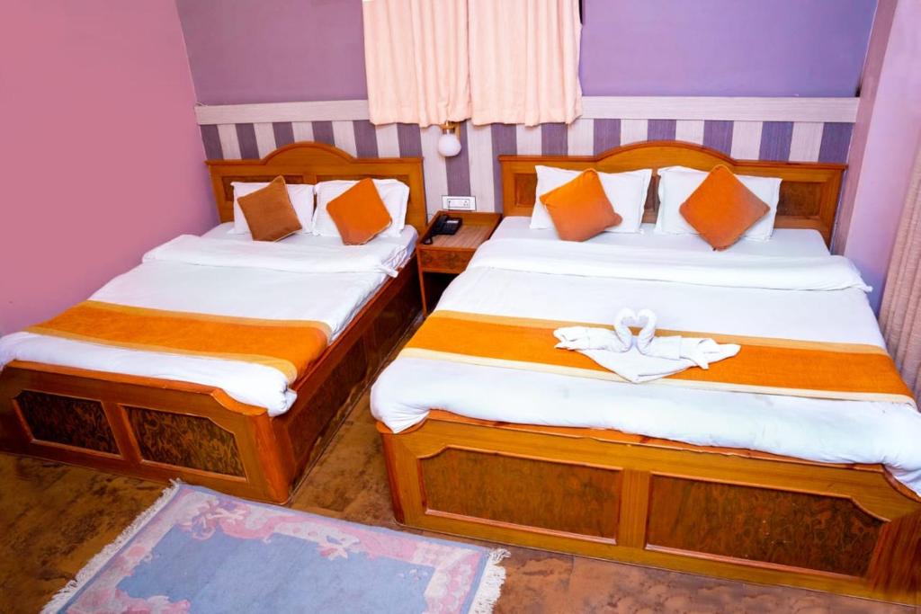 two beds in a small room with two bedsskirts at Hotel Kamana in Pokhara