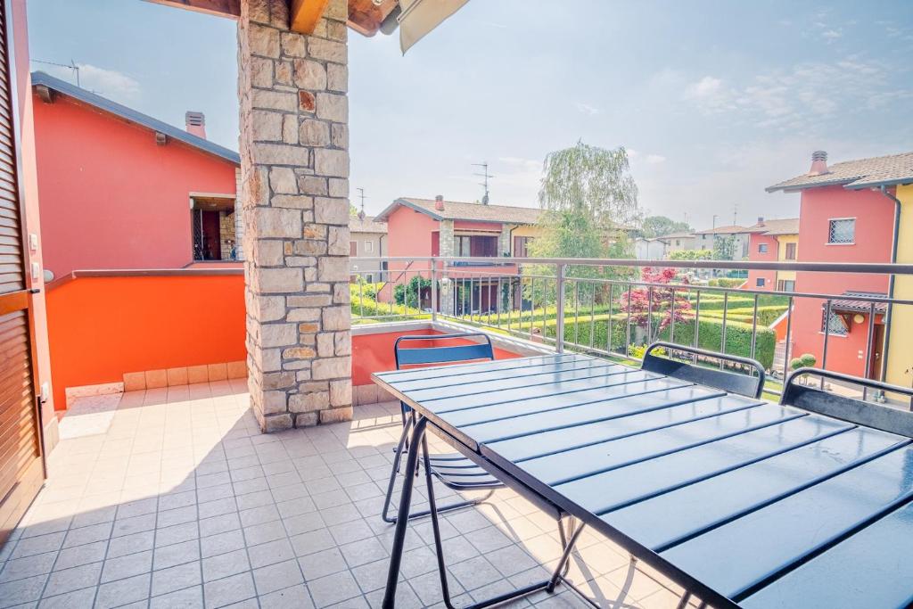 una mesa en el balcón de una casa en Garda Orange Apartment - Italian Homing, en Desenzano del Garda