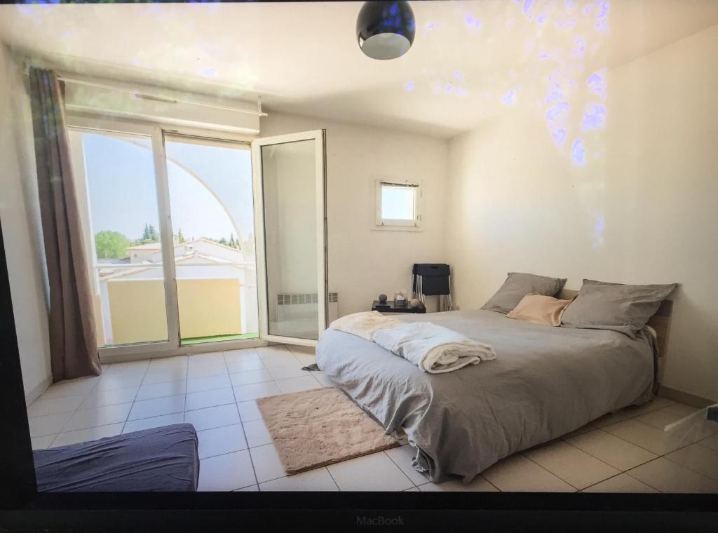 1 dormitorio con cama y ventana grande en Studio ensoleillé sur Montpellier en Montpellier