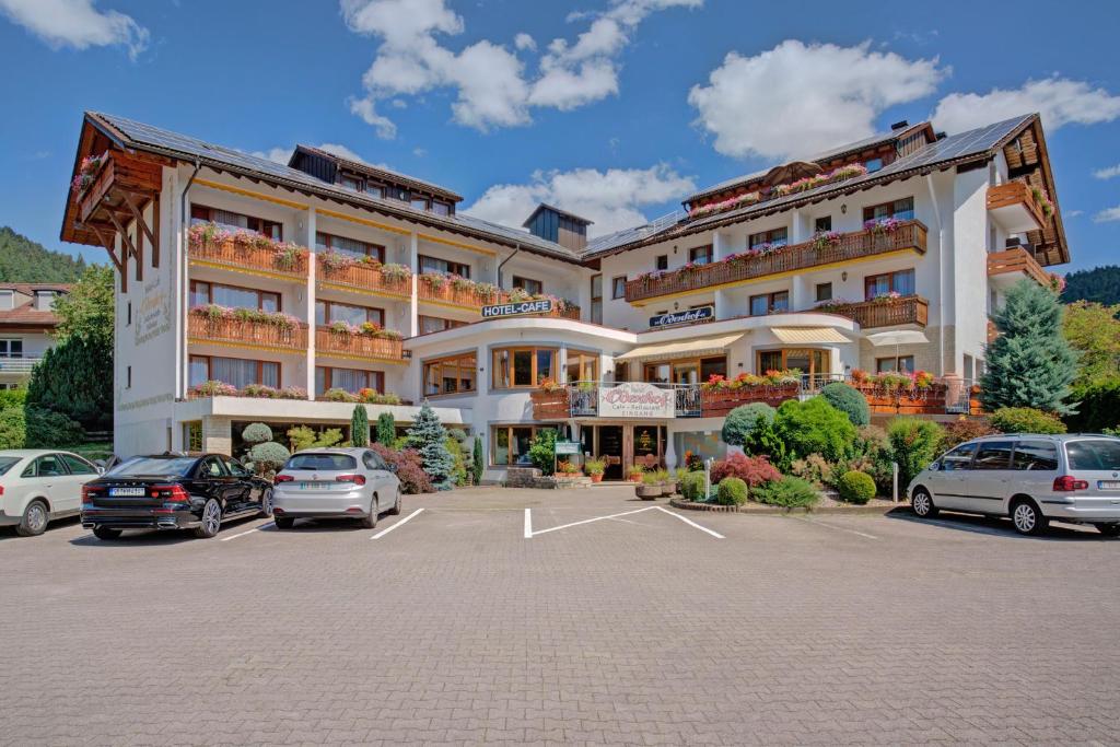 a large building with cars parked in a parking lot at Ferienhotel Ödenhof in Baiersbronn