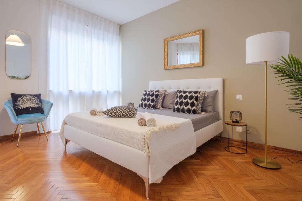 uma sala de estar com uma cama e uma cadeira azul em Padova Lux Station em Pádua