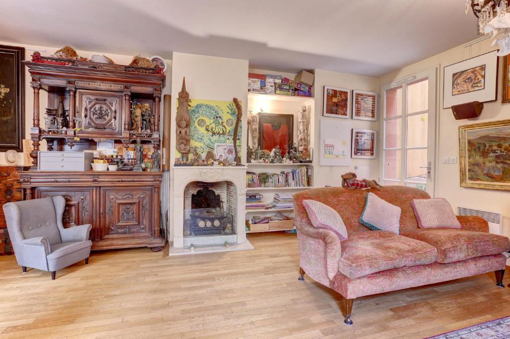 un salon avec un canapé et une cheminée dans l'établissement La Pompadour- Versailles, à Versailles