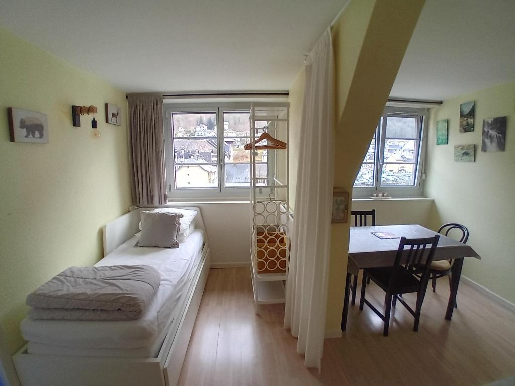 een kleine kamer met een bed, een tafel en een raam bij Chalet Bruyère in Cauterets