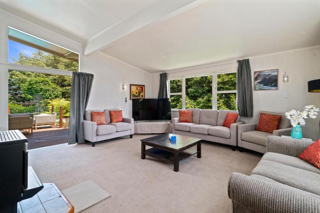 a living room with two couches and a tv at Pool House- Springfield in Rotorua