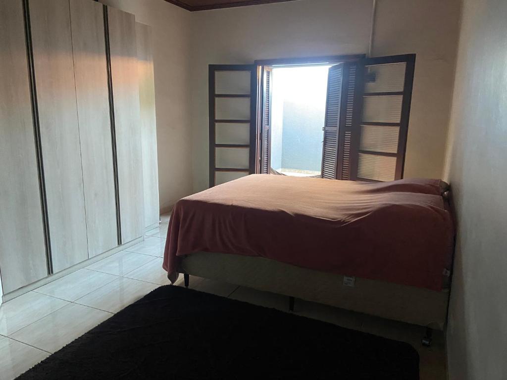 a small bedroom with a bed and a window at Casa de Andirá in Andirá