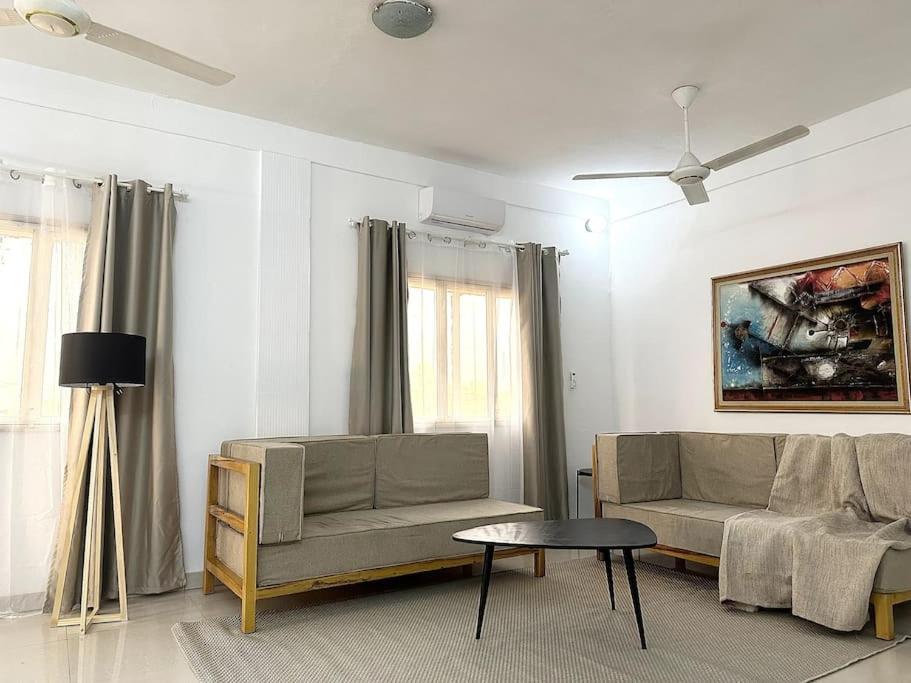 uma sala de estar com um sofá e uma mesa em Appartement - Le Grège em Ouagadougou