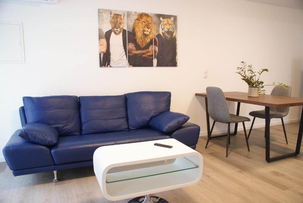 ein Wohnzimmer mit einem blauen Sofa und einem Tisch in der Unterkunft STAGE4 in Feldkirch