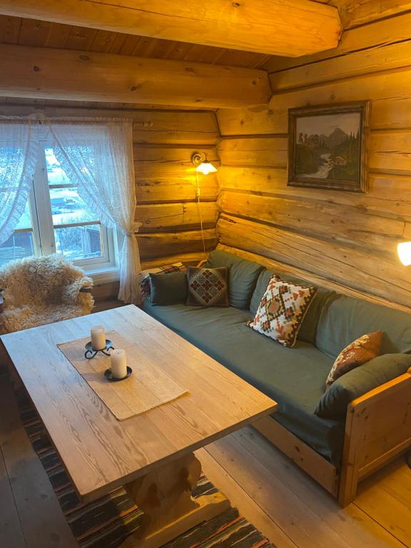 a living room with a couch and a table at Stallen - koselig lite hus på gårdstun in Skjåk