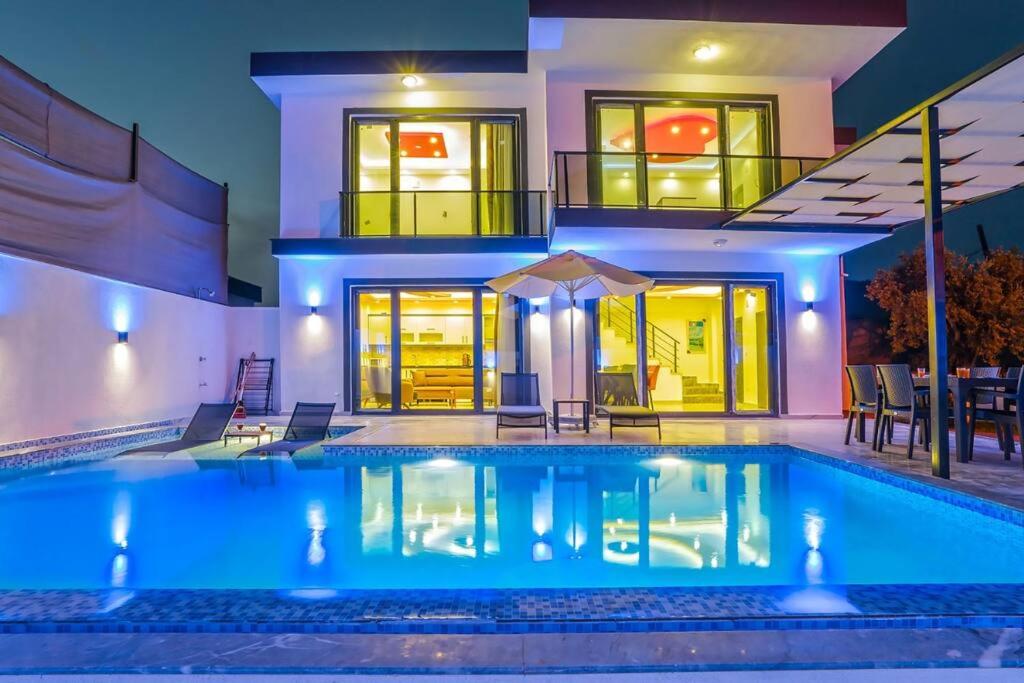 uma casa com piscina em frente a uma casa em Villa Hazal 2 / Kalkan em Kas