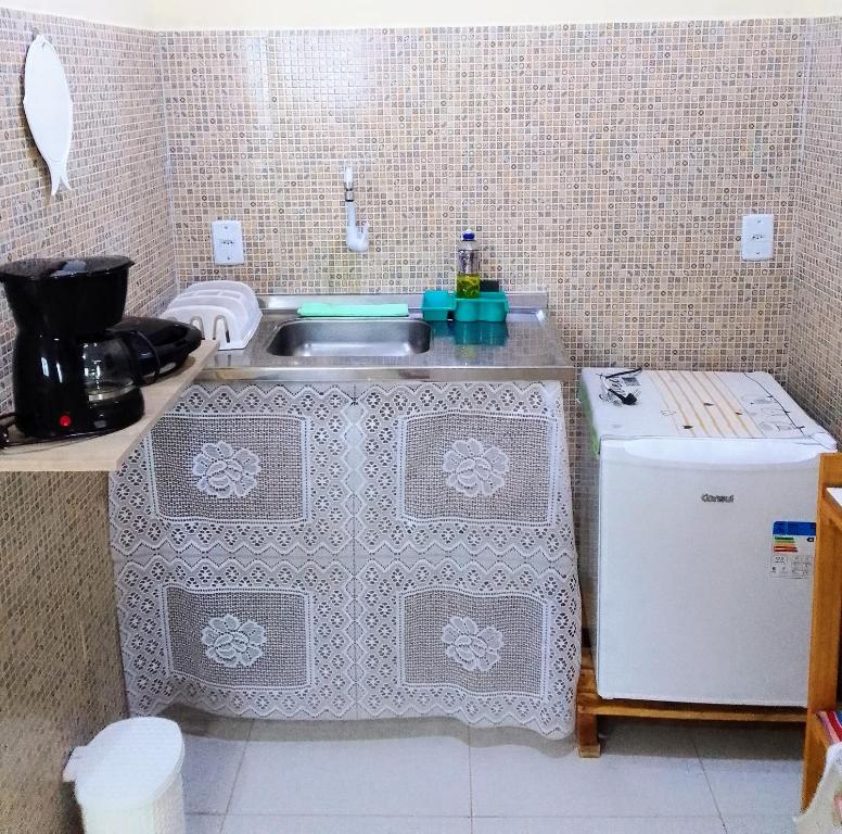 a small kitchen with a sink and a refrigerator at Flores do Riacho in São Miguel dos Milagres