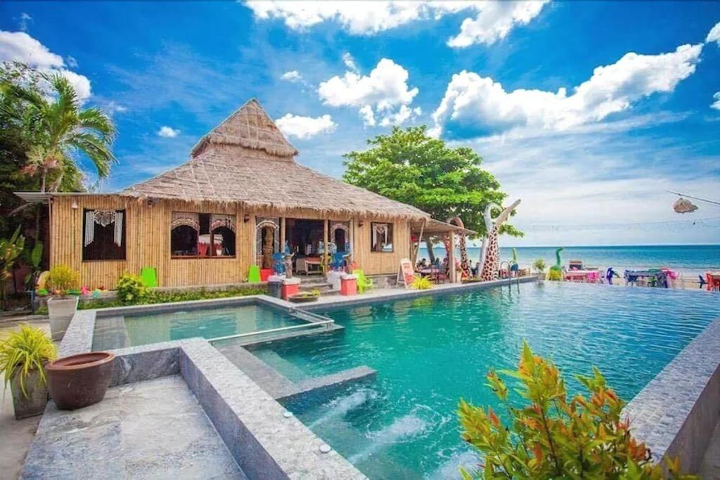 um resort com uma piscina junto ao oceano em Chaba Bungalows em Ban Ai Dao