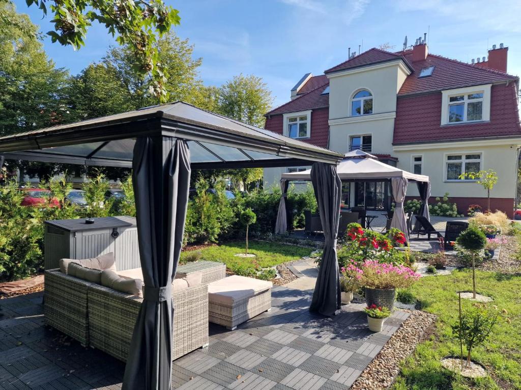 a gazebo in the backyard of a house at Villa Babette - Ubernachtung, Parkplatz, Kurtaxe, Wifi, Aufraumung - Alles im Preis! in Świnoujście