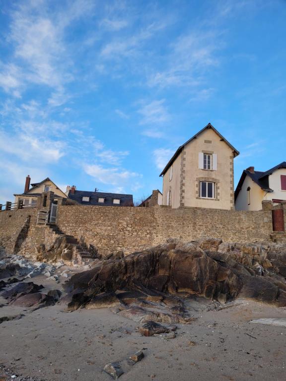 een huis op een stenen muur bij het strand bij Ker Lucie- Les Gîtes de la Côte d'Amour ! in Batz-sur-Mer