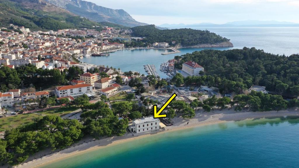 eine Insel mit einem gelben Pfeil, der ins Wasser zeigt in der Unterkunft Beach rooms Riviera - Žuta Kuća in Makarska