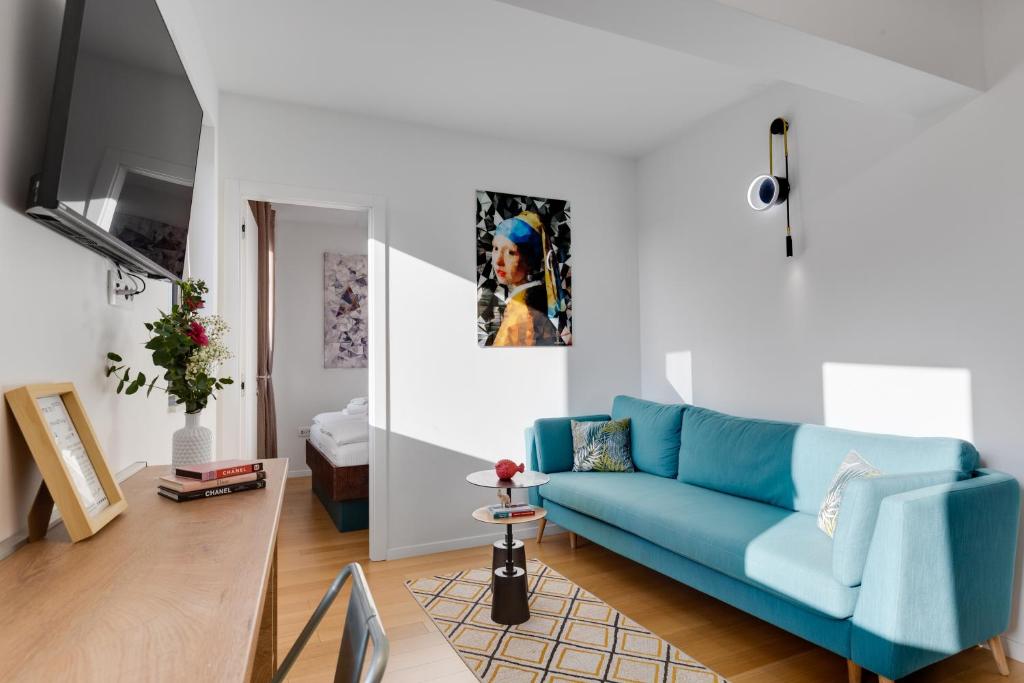 a living room with a blue couch in a room at Tres Fenestras Zadar - private parking in Zadar