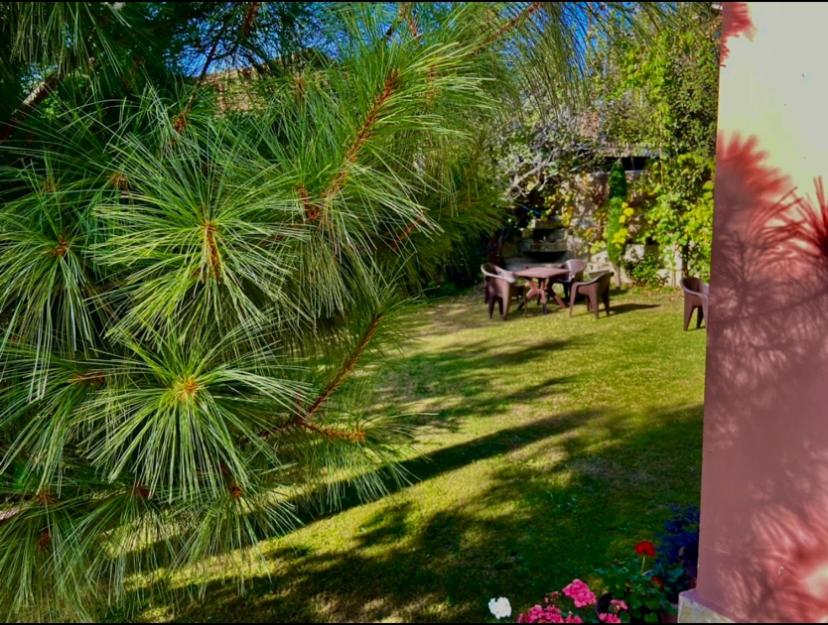 uma vista para um jardim com uma mesa e cadeiras em The Upscale Inn em Srinagar