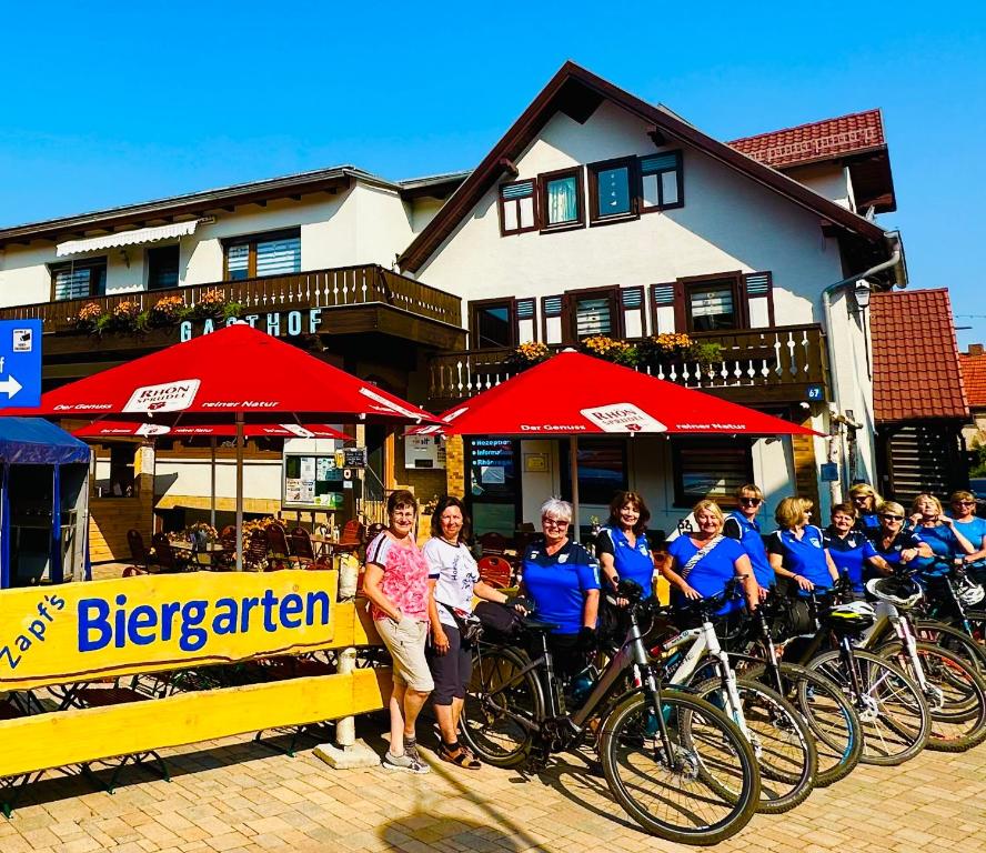 een groep mensen die naast hun fietsen staan bij Landgasthof und Pension Zum löwen in Bischofsheim an der Rhön