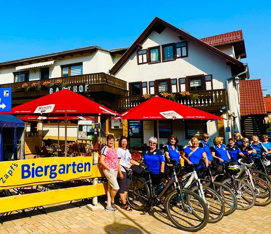 Un groupe de personnes debout à côté de leurs vélos dans l'établissement Landgasthof und Pension Zum löwen, à Bischofsheim an der Rhön