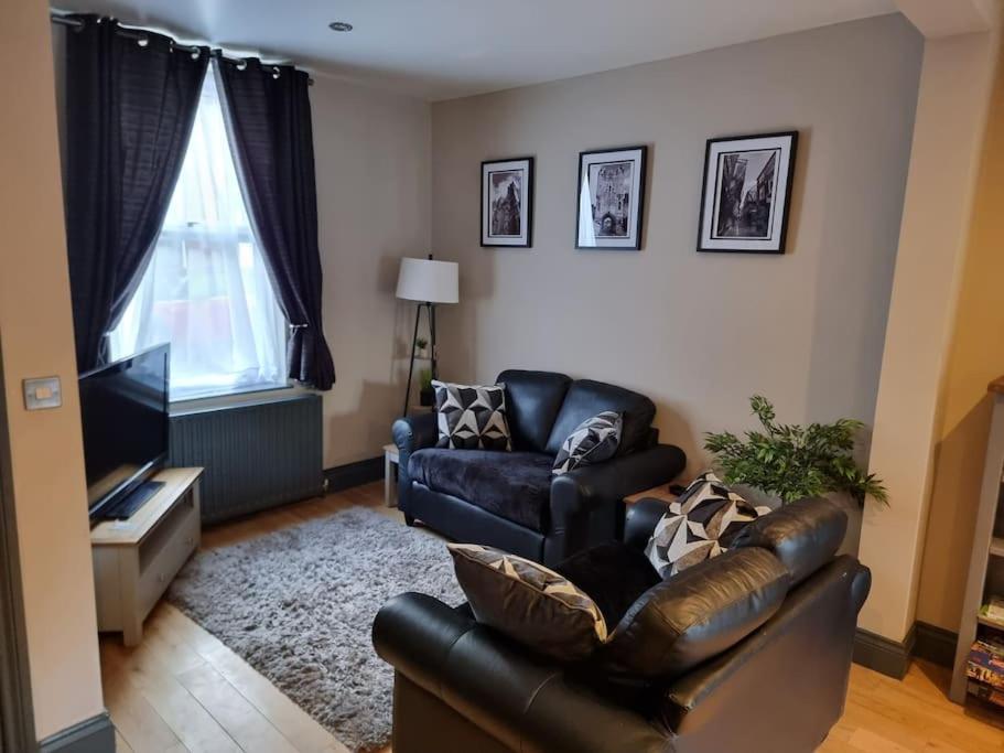 a living room with a leather couch and a television at Cosy home in York in York