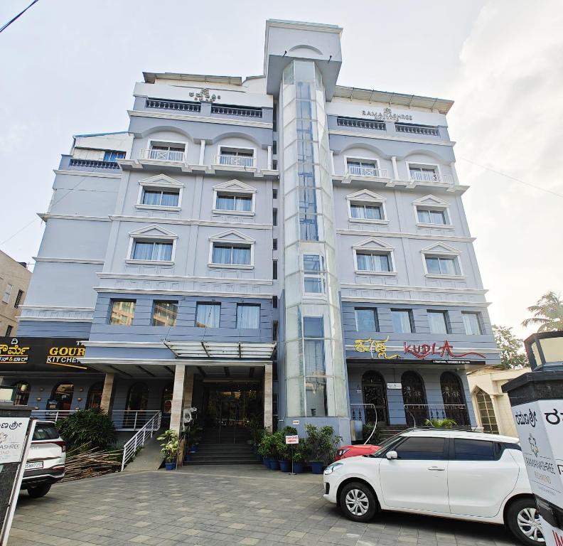 a white car parked in front of a building at Hotel Ramanashree Richmond in Bangalore