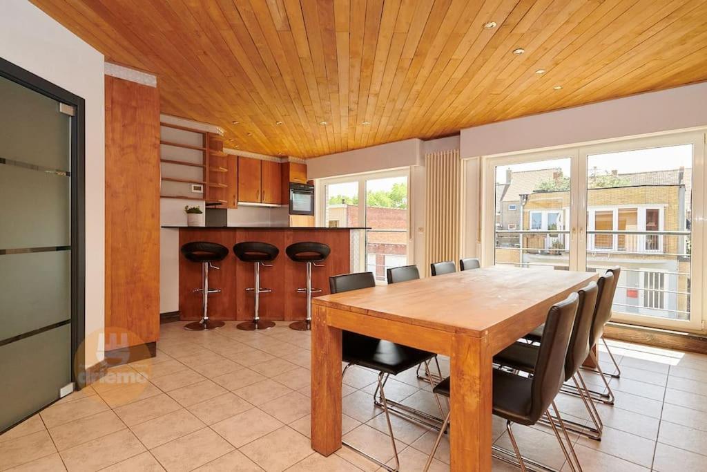 ein Esszimmer mit einem Holztisch und Stühlen in der Unterkunft Huis voor 8 personen - NACHT 23 in De Panne