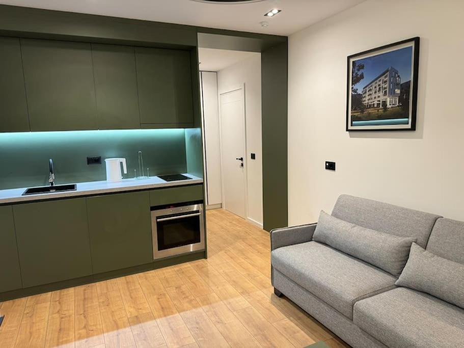 a living room with a couch and a kitchen at Boutique Flat in the City Center in Tirana