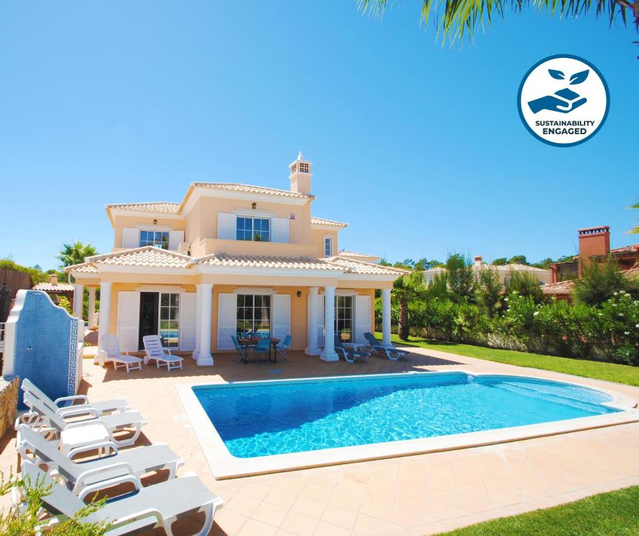 eine Villa mit einem Pool vor einem Haus in der Unterkunft Villa Dalia by Algarve Vacation in Almancil