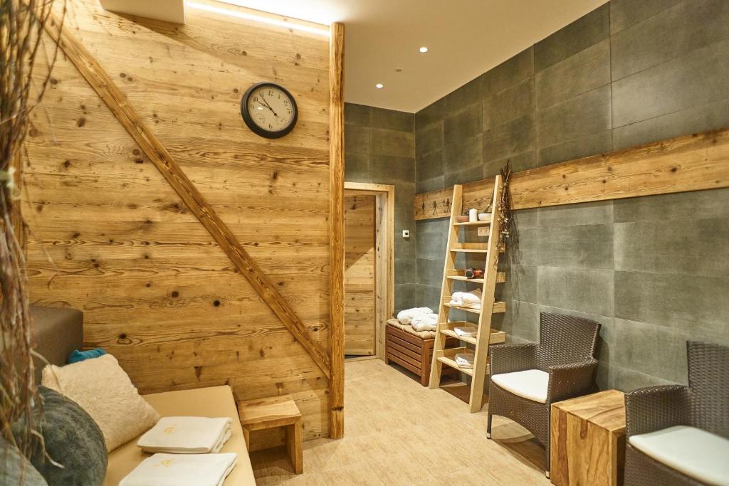 a room with a wooden wall with a clock at Hotel Toč in Lipova Lazne