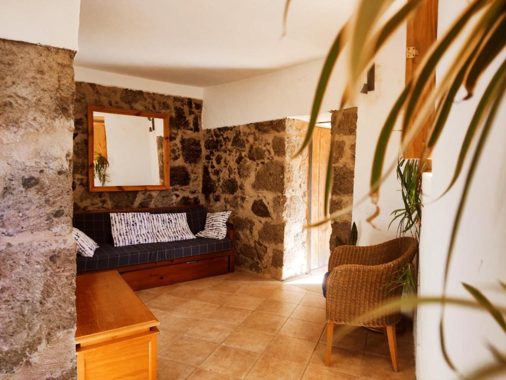 salon z kanapą i lustrem w obiekcie Casas cuevas, Los Cabucos w mieście Agaete