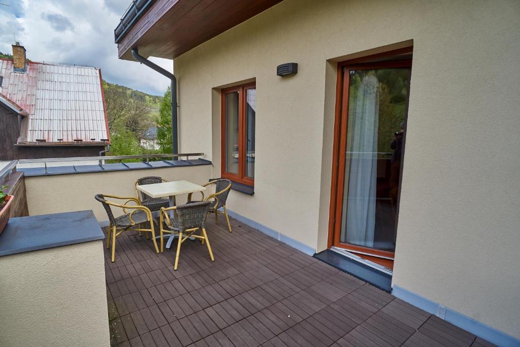 a patio with a table and chairs on a balcony at Hotel Toč in Lipova Lazne