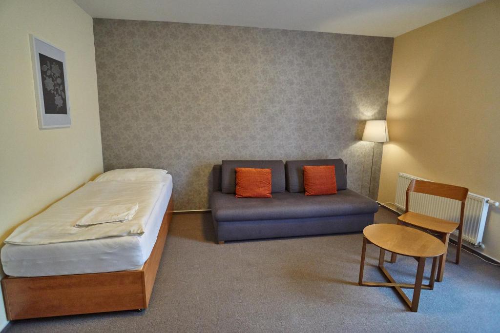 a hotel room with a bed and a couch at Hotel Toč in Lipova Lazne