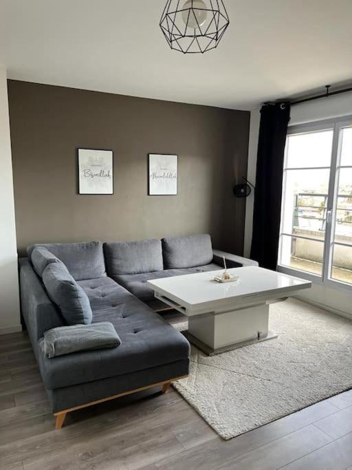 uma sala de estar com um sofá e uma mesa de centro em Big duplex 15 min from Paris city center - Metro station Line 5 em Bobigny