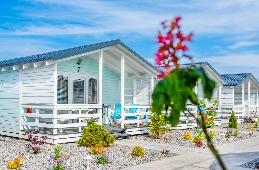 una fila di case bianche con dei fiori davanti di TURKUSOWE ZACISZE a Kopań