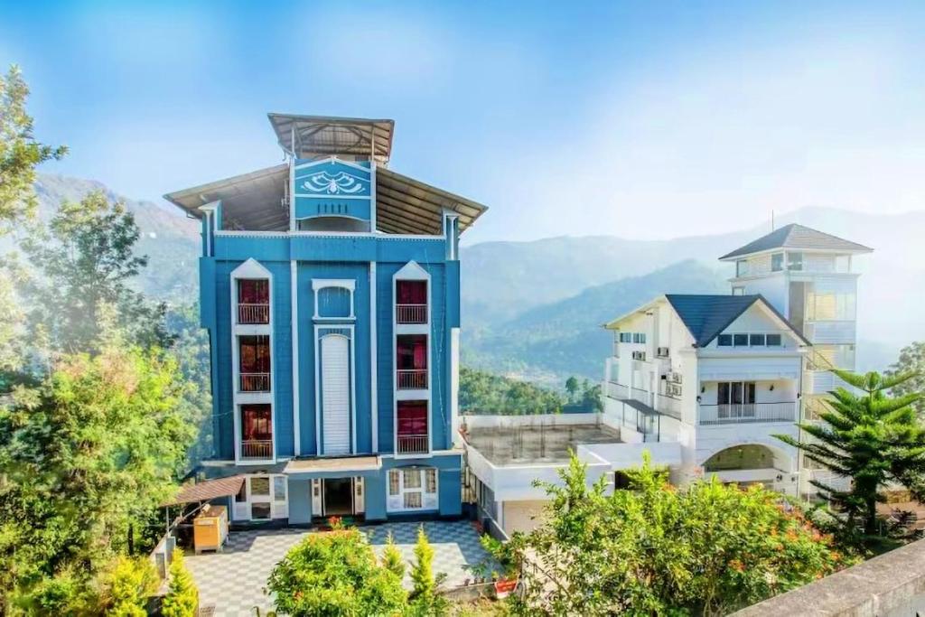 une maison avec un bâtiment bleu et blanc dans l'établissement The View Munnar, à Anachal