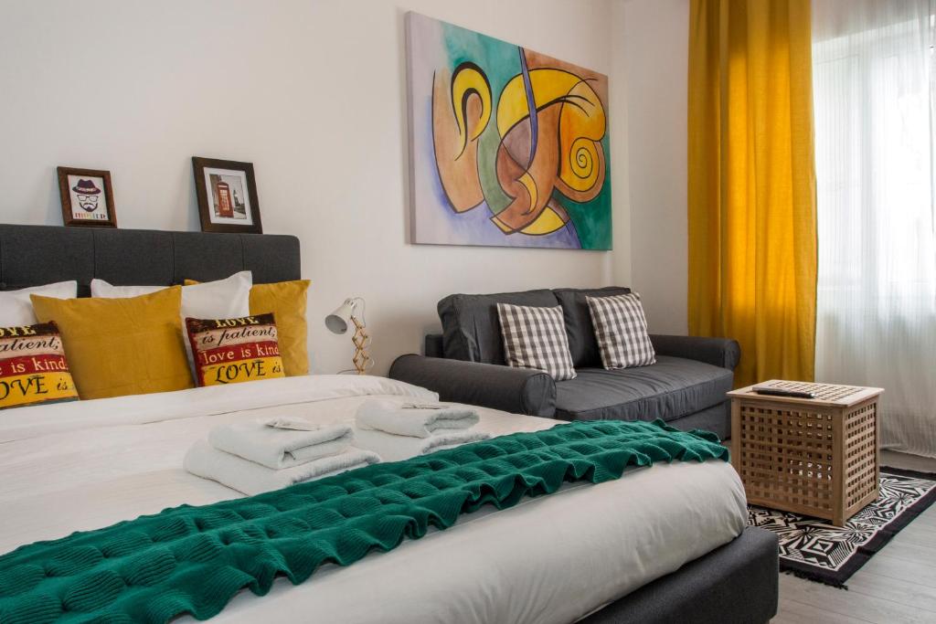 a bedroom with a large bed and a couch at Old Town Premium Apartment by MRG in Bucharest