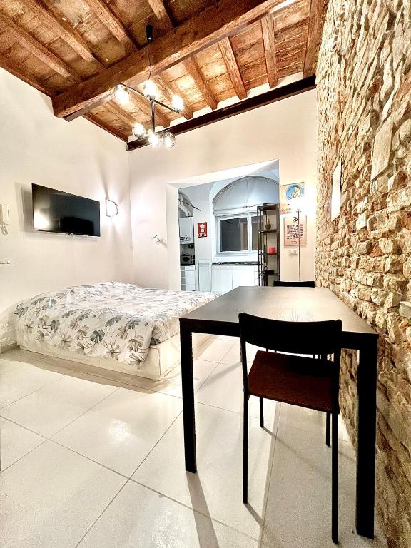 ein Schlafzimmer mit einem Bett und einem Tisch mit einem Stuhl in der Unterkunft Da Carlin in Cesena