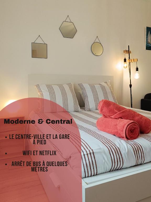 una camera da letto con un letto con asciugamani rossi di Moderne & au centre - Studio a Lorient