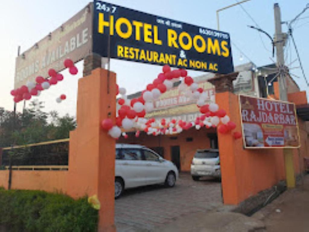 una señal de habitaciones de hotel frente a un estacionamiento en Hotel Rajdarbar Fatehpur, en Fatehpur Sīkri