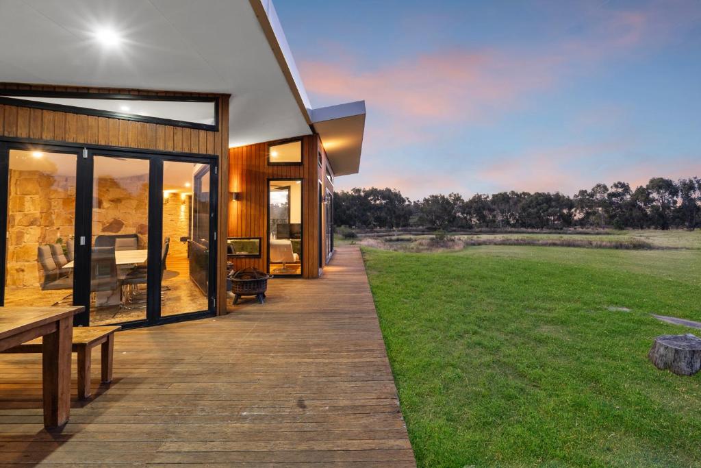 a house with a deck with a view of a field at Unique and Modern Farm Stay with Pool and Foosball and Yard in Buninyong