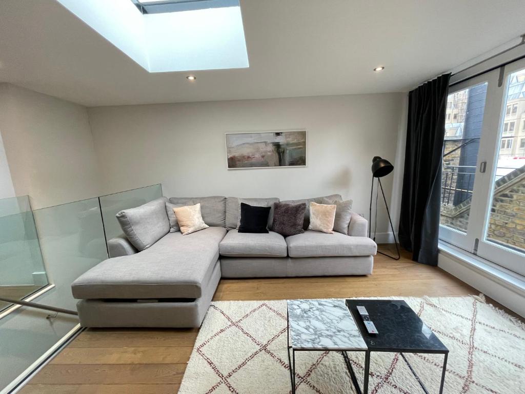 a living room with a couch and a window at Drury Lane Residences in London