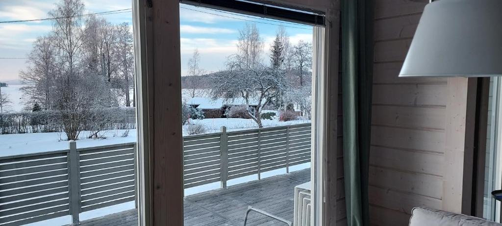 a window with a view of a snow covered yard at Seeblickferienhaus in Lahti