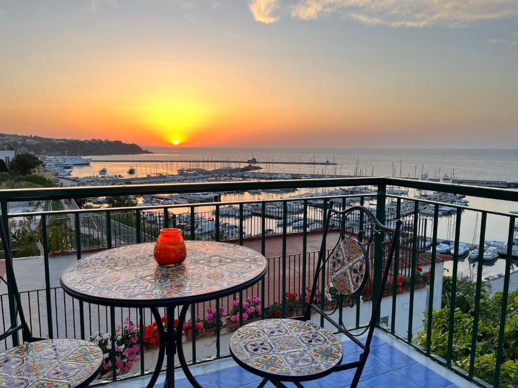 un tavolo e sedie su un balcone con vista sul tramonto di Punta Lingua Relais - Room 2 Sunset Terrace a Procida