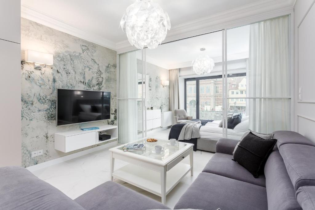 a living room with a couch and a tv at Rent like home - Apartament w Deo Plaza in Gdańsk