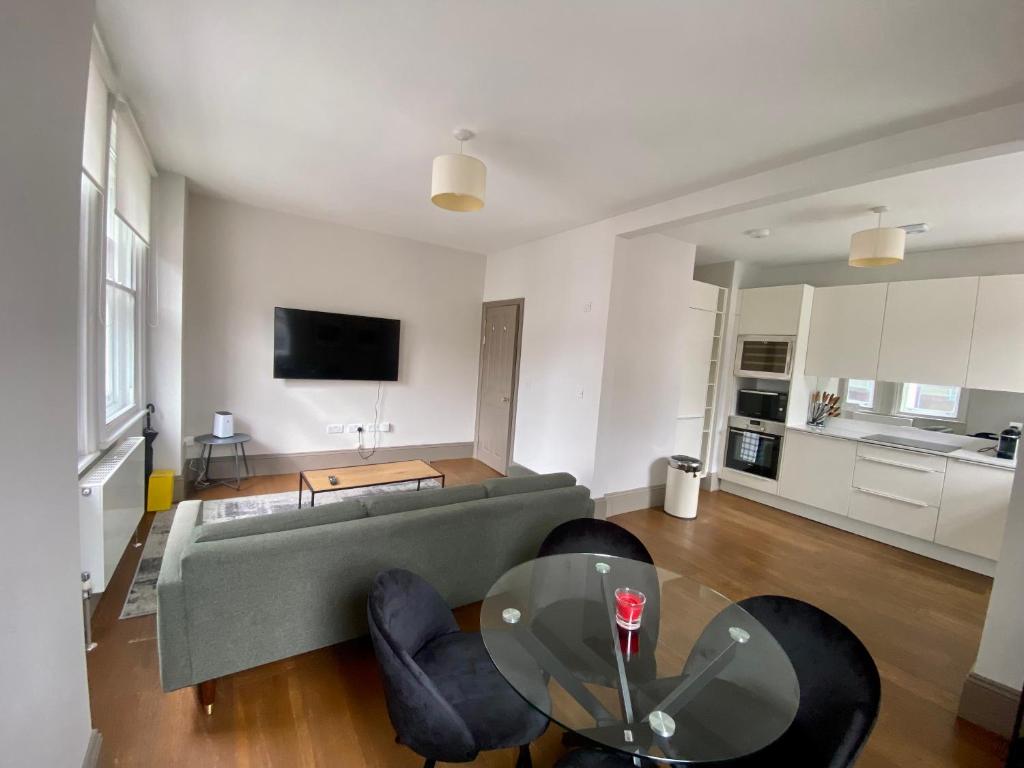 - un salon avec un canapé et une table en verre dans l'établissement Modern flat near Oxford Street, à Londres