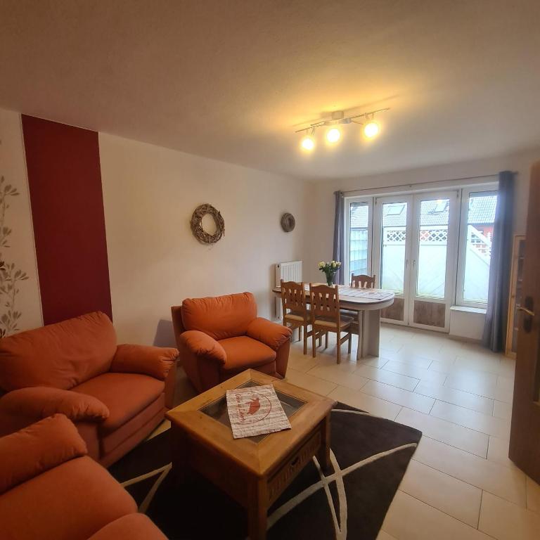 a living room with two couches and a table at Haus Dithmarschen in Hemmingstedt