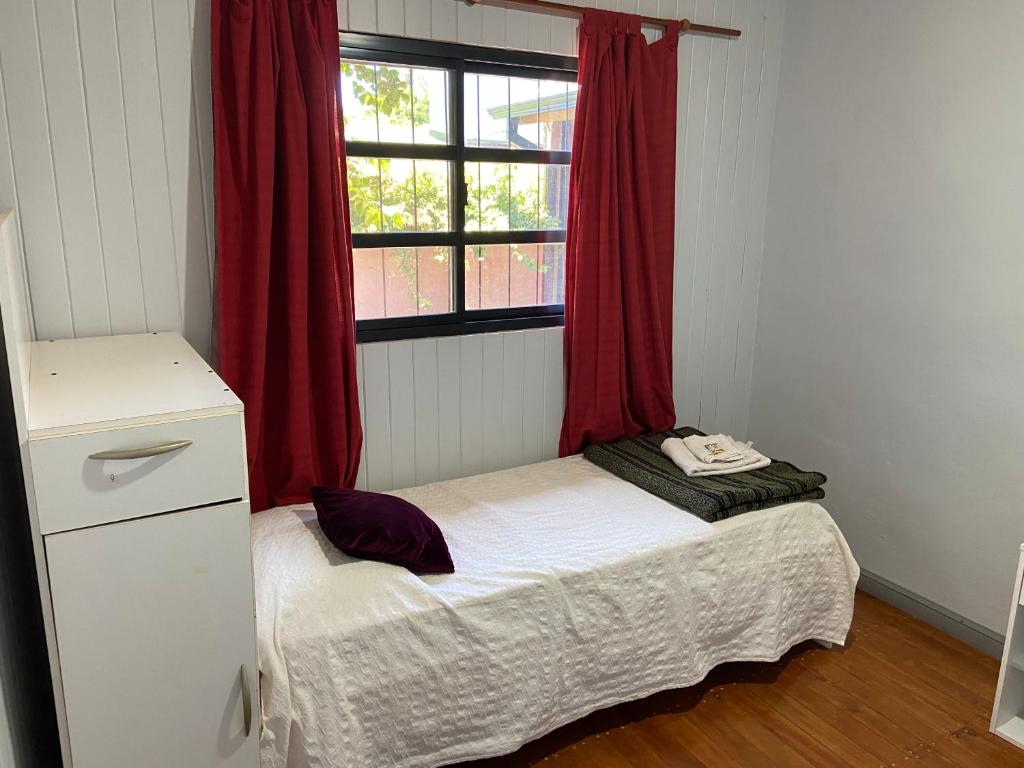 małe łóżko w pokoju z oknem w obiekcie Cabañas del Chachi w mieście Oberá